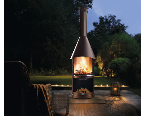 Gartenszene mit Kaminofen, Holz und Gartenmöbeln auf einer Terrasse