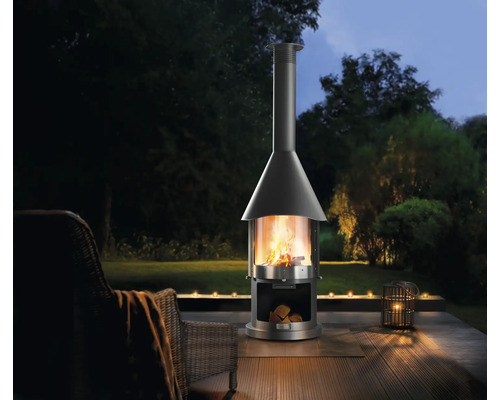 Freistehender Aussenkamin auf einer Terrasse mit Sitzgelegenheit und Kerzen.