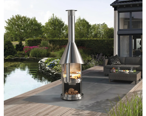 Edelstahl-Aussenkamin mit Holz und Grill auf Terrasse mit Gartenteich