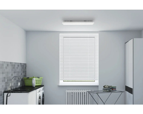 Buanderie lumineuse avec machine à laver, évier, panier à linge, étendoir et store vénitien