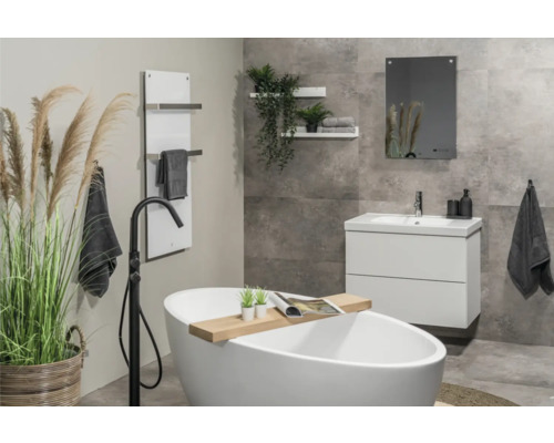 Salle de bains moderne avec baignoire îlot, lavabo, miroir et sèche-serviettes