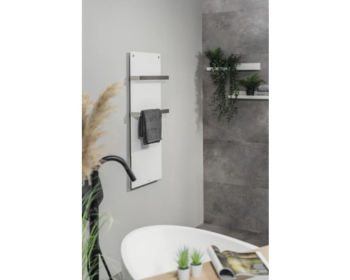 Salle de bains avec baignoire, sèche-serviettes et étagères murales avec décoration.