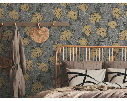 Schlafzimmer mit einer grauen Blättertapete, einem Bett und einer Garderobe.