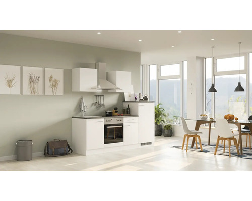 Cuisine lumineuse avec kitchenette, hotte et coin repas dans un espace ouvert.