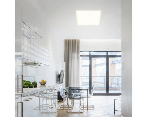 Cuisine moderne avec table à manger et plafonnier carré.