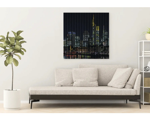 Tableau mural avec un motif de skyline au-dessus d''un canapé dans un salon.