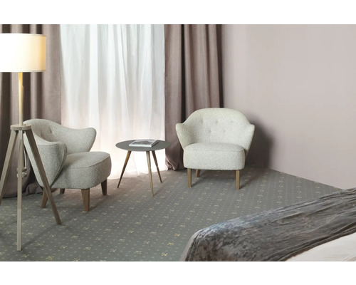 Zwei Sessel und ein runder Tisch stehen in einem hellen Raum mit Vorhängen und einer Stehlampe.