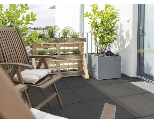 Balcon avec chaises en bois, étagère en palettes et bacs à plantes sur des dalles de sol