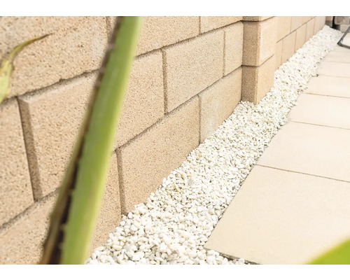 Mur en pierres de béton avec gravier décoratif et dalles de trottoir