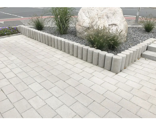 Chemin de jardin aménagé avec des bordures de gazon, des plantes et des pierres