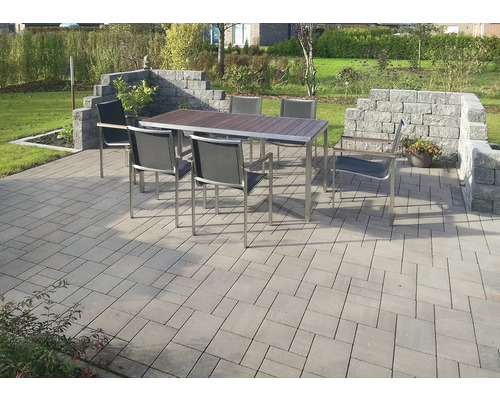 Scène de jardin avec table à manger, chaises et pavés en pierre