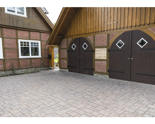 Allée pavée devant une maison avec portail en bois et éléments en bois