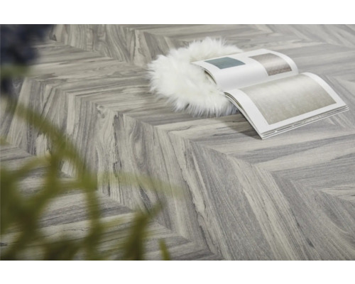 Verlegtes Vinyl in Fischgrätmuster mit Buch und Dekoration