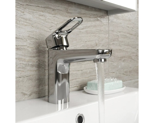 Mitigeur de lavabo brillant en métal sur un lavabo avec de l''eau qui coule