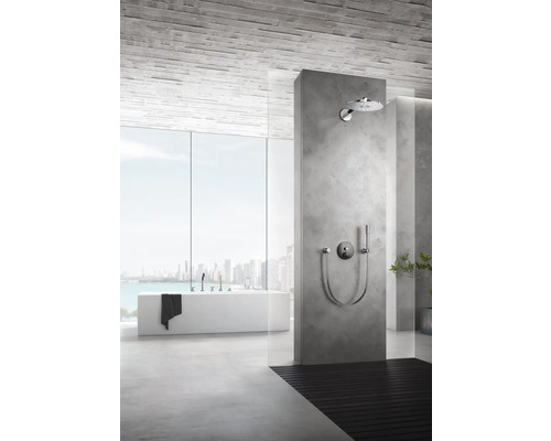 Salle de bains avec douche, baignoire et grande fenêtre donnant sur une ville