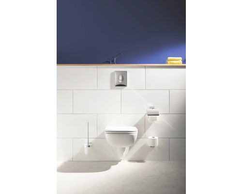 Salle de bains moderne avec WC suspendu, réservoir, porte-papier toilette et brosse.