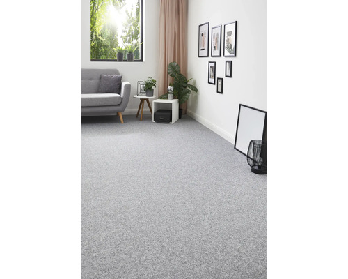 Grauer Teppich in einem hellen Wohnzimmer mit Sofa, Tisch und Dekoration