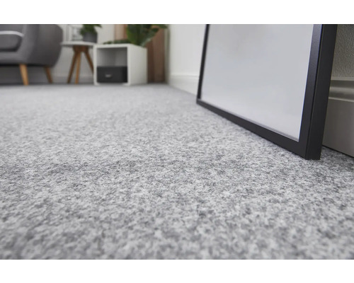 Nahaufnahme eines hellgrauen Teppichbodens in einem Raum.