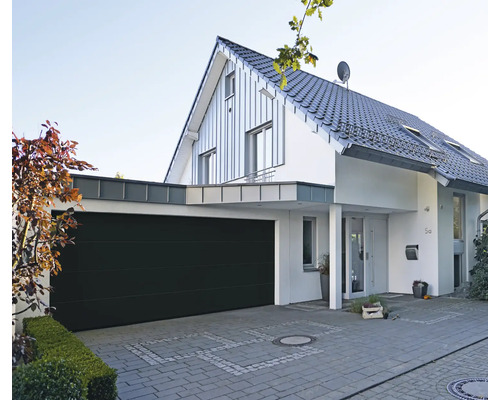 Modernes Haus mit Garage und gepflasterter Einfahrt.