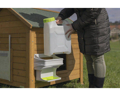 Hühnertränke mit Wasserkanister an einem Hühnerstall befestigt