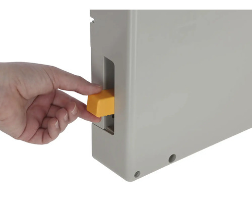 Eine Hand betätigt einen gelben Schalter an einem grauen Gehäuse.