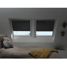 Chambre avec fenêtres de toit et stores plissés noirs pour les fenêtres