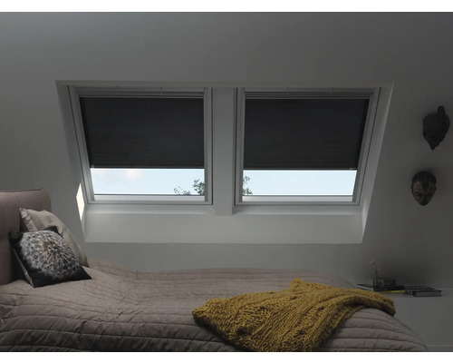 Chambre avec fenêtres de toit et stores plissés noirs pour les fenêtres