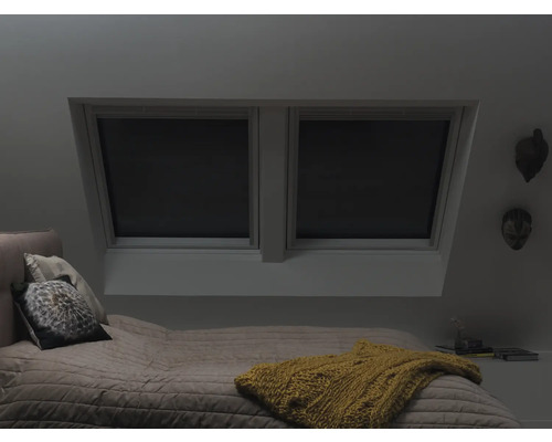 Chambre à coucher avec fenêtres de toit et stores occultants pour fenêtres de toit.