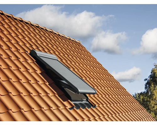 Fenêtre de toit avec volet roulant sur un toit en tuiles