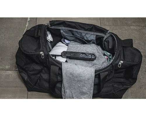 Sac de sport ouvert avec vêtements et multiprise