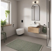 Salle de bain moderne avec lavabo, miroir, WC et tapis de bain vert