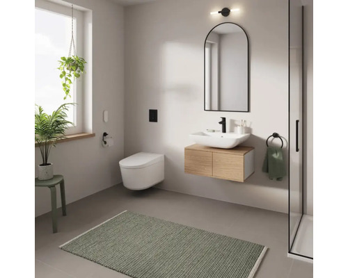 Salle de bain moderne avec lavabo, miroir, WC et tapis de bain vert