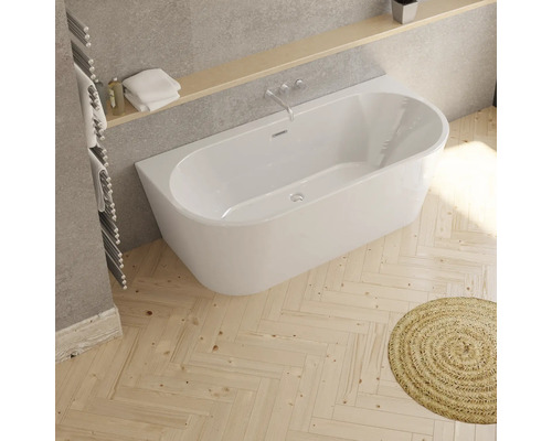 Baignoire intégrée dans une salle de bains avec plancher en bois et tapis rond