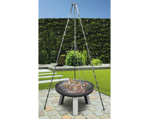 Gril pivotant avec des aliments grillés dans le jardin