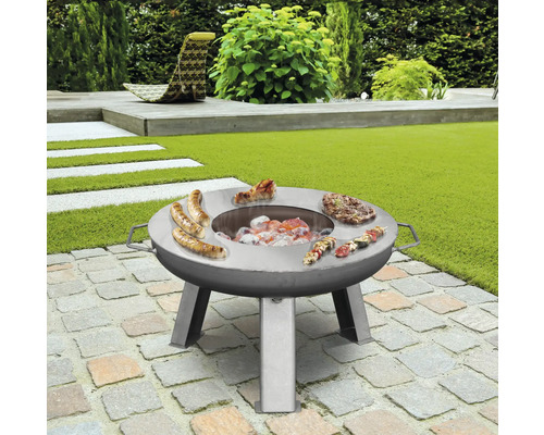 Table de grill en acier inoxydable avec saucisses, steaks et brochettes dans le jardin