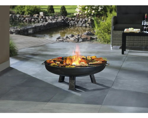 Brasero avec des grillades sur une terrasse avec bassin de jardin