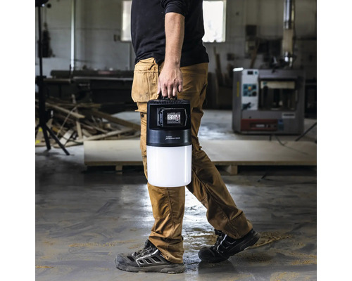 Une personne porte une lampe de chantier LED portative