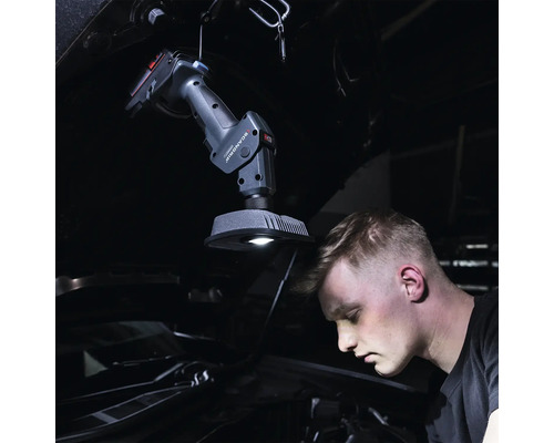 Scène d''atelier avec une lampe de travail ScanGrip améliorant l''éclairage du compartiment moteur lors d''une réparation