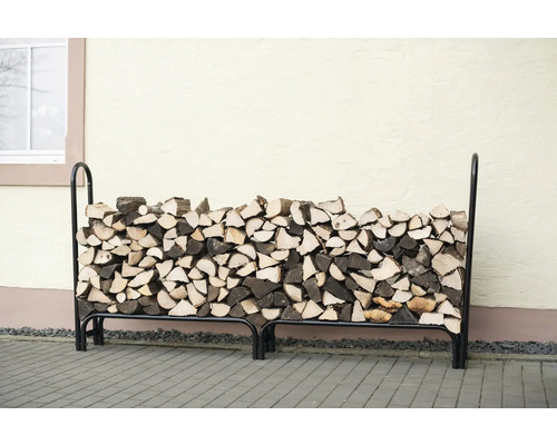 Bois de chauffage empilé dans un support à bois en métal noir.