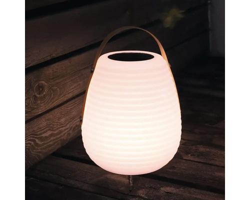 Leuchtende Solarlaterne mit Tragegriff auf Holzboden