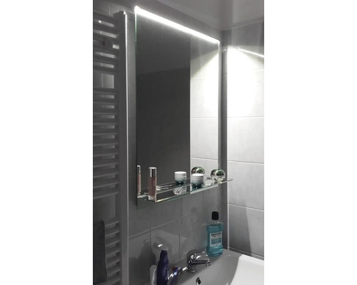 Salle de bains avec miroir éclairé et lavabo