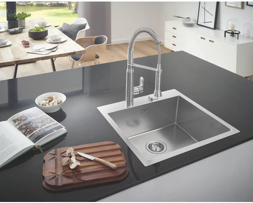 Évier avec robinet et ustensiles de cuisine sur un comptoir de cuisine.