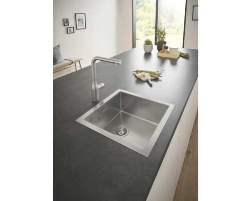 Évier en acier inoxydable avec robinet dans une cuisine moderne.