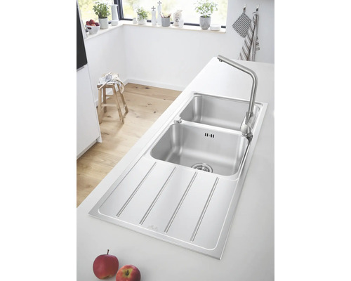 Évier en acier inoxydable avec égouttoir et robinet dans une cuisine claire