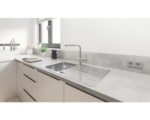 Évier en acier inoxydable avec égouttoir dans une cuisine claire