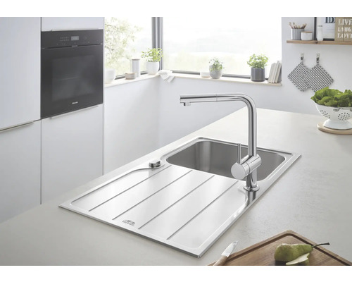 Évier en acier inoxydable avec robinetterie dans une cuisine claire