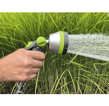 Une main tient un pistolet d'arrosage qui pulvérise de l'eau.