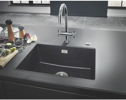 Évier de cuisine noir en matériau composite avec robinet sur un plan de travail