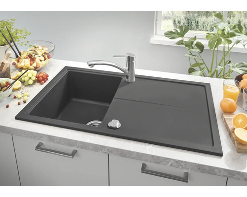 Évier en granit avec égouttoir et robinet sur un comptoir de cuisine