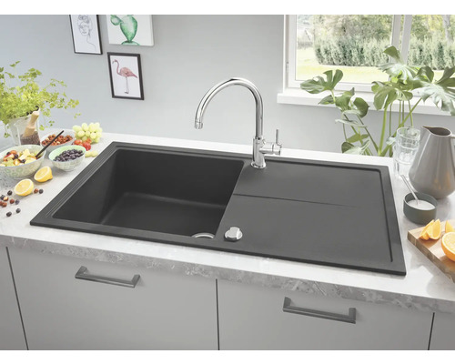 Évier de cuisine gris foncé avec égouttoir et robinet sur un plan de travail